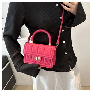 Detail of hot pink mini crossbody bag with geometric embossed pattern and gold clasp