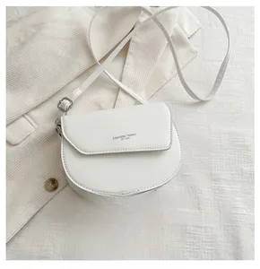 Detailed view of cream saddle bag with adjustable strap and smartphone for size reference