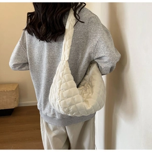 Detailed view of the quilted nylon puffer bag showing soft padded texture and stitching
