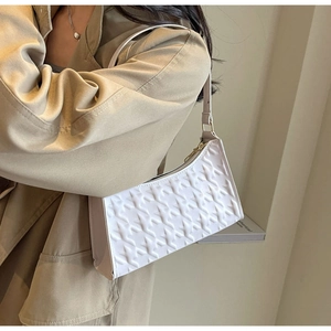 Detail of white star embossed texture and metal zipper on a French underarm bag
