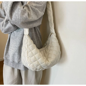 Detail of white quilted nylon dumpling bag showing high-quality stitching and texture