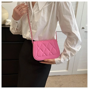 Pink quilted crossbody bag with gold chain strap shown on model for size perspective