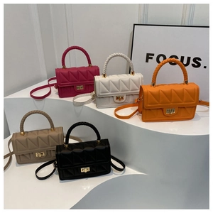 Detailed view of colorful quilted crossbody bags with woven handles and metal locks
