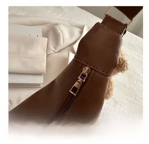 Detail of smooth bronze zipper and brown leather texture on a casual commuter bag