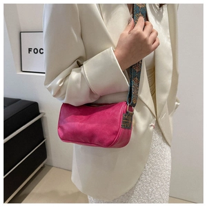 Detail der rosaroten Mini-Zylindertasche mit breitem Schultergurt im Ethno-Stil
