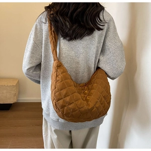 Rear view of caramel quilted nylon crossbody bag showing its large capacity and wide strap