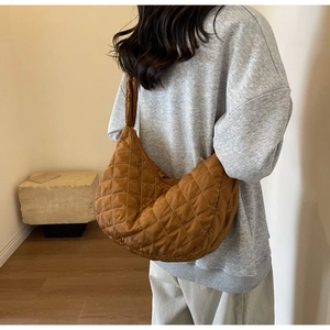 Detail view of the brown quilted nylon dumpling bag showing its soft texture and large capacity