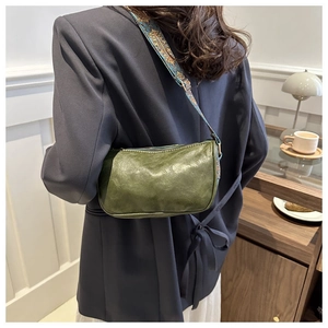 Detail der vintage grünen Ledertasche mit buntem gewebtem Schultergurt im Ethno-Stil