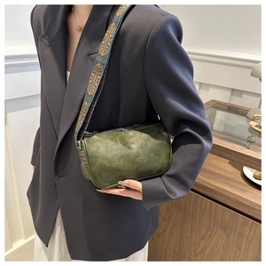 Details der grünen Retro-Tasche mit Vintage-Lederstruktur und Ethno-Stickerei-Gurt