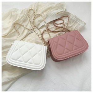 Detail view of quilted leather texture and metal chain straps on white and pink bags