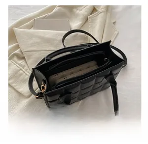 Detail of black quilted tote bag with spacious interior and functional zipper pocket