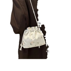 Off-white canvas crossbody bag with floral embroidery and drawstring closure
