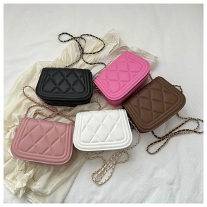 Flat lay of colorful quilted crossbody bags with chain straps in five various shades