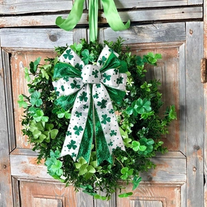 St. Patrick's Day shamrock wreath with large clover bow hanging on a rustic wooden door