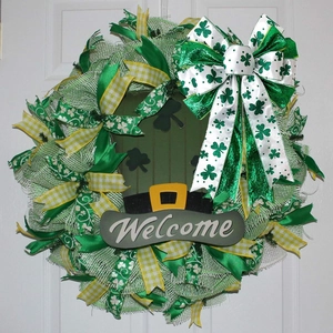 St. Patrick's Day welcome wreath with clover ribbons and green mesh on a white door