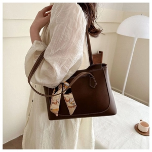 Detail of dark brown tote bag with white contrast stitching and vintage floral ribbon