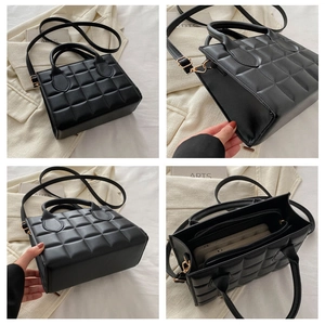 Detail view of black quilted handbag with gold hardware and multiple inner compartments