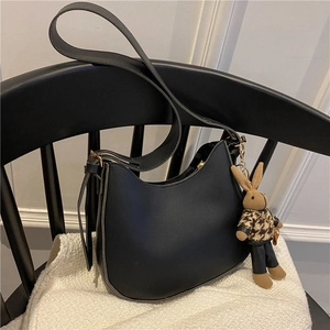Chic black half-moon underarm bag with adjustable strap and cute rabbit pendant decoration