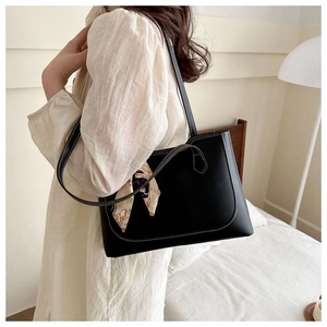 Close-up of black tote bag with white contrast stitching and silk scarf detail
