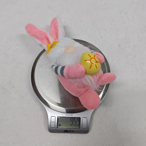Easter gnome plush with rabbit ears holding an egg, weighing 95.9g on a scale