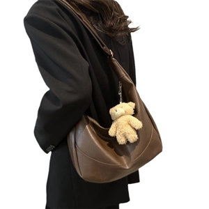 Deep brown crescent shoulder bag with cute teddy bear charm for daily casual commute
