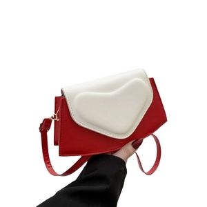 Chic red and white colorblock crossbody bag with heart shaped flap and leather strap