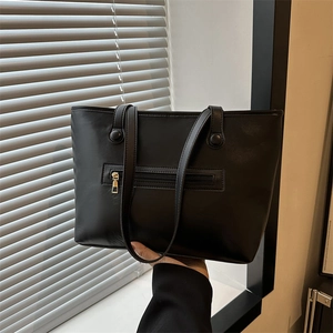Classic black tote bag with gold zipper pocket and slim shoulder straps for daily commute