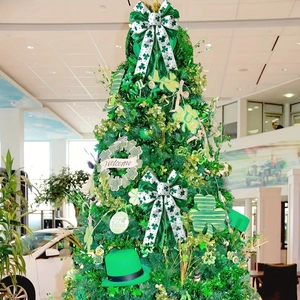 Saint Patrick's Day green tinsel tree featuring lucky clover bows and a top hat decoration