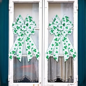 St. Patrick's Day green clover bows displayed on a white wooden window frame decor