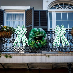 St. Patrick's Day green clover bows and festive wreath displayed on outdoor iron railing