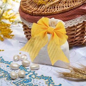 Detalle de bolsa de regalo de lino con gran lazo de malla amarilla y cordón ajustable