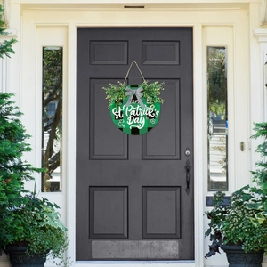 Detail of St. Patrick's Day wooden door sign with green buffalo plaid and faux greenery