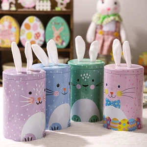 Detail of Easter tinplate candy jars with cute fabric bunny ears in assorted pastel colors