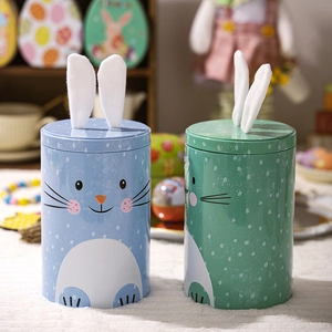 Detail of blue and green Easter tin canisters with plush bunny ears and dot patterns