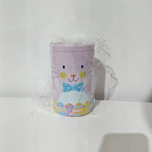 Close-up of a purple Easter bunny tin box with colorful egg patterns and bow tie