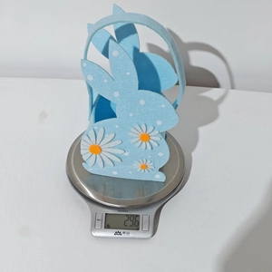Detailed view of light blue felt Easter bunny basket showing its weight on a digital scale