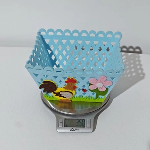 Detail of blue felt Easter basket with colorful rooster patch weighing 35g on a scale