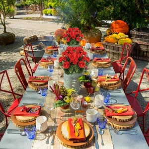 Decoración de mesa con geranios rojos artificiales en macetas de metal para otoño