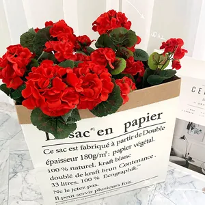 Géraniums rouges artificiels dans un sac en papier blanc pour déco intérieure
