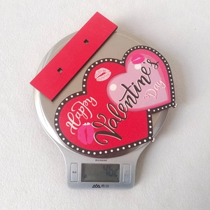 Kitchen scale showing 46.2g weight of a wooden heart Valentine's Day decor sign