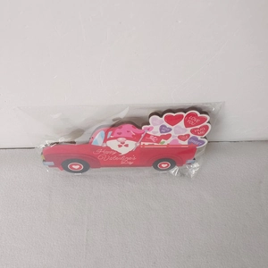 Close-up of wooden Valentine's truck ornament with red heart balloons and gnome pattern