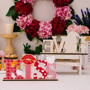 Detail of wooden KISS letters with heart patterns for Valentine tabletop decoration