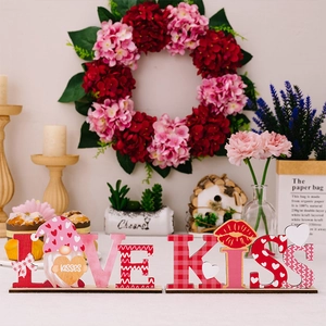 Close-up of wooden LOVE and KISS table ornaments with heart gnome and plaid patterns