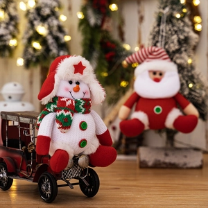Close-up of a plush Christmas snowman with plaid scarf on a vintage red metal sled