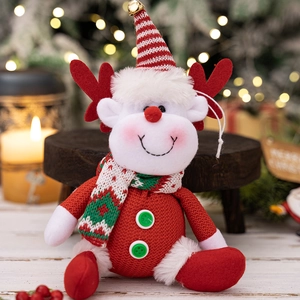 Detailed close-up of a Christmas reindeer plush toy with red hat and golden bell accent