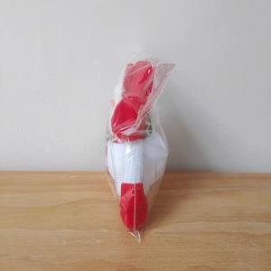 Detail view of festive red plush Santa and reindeer figurines in protective packaging