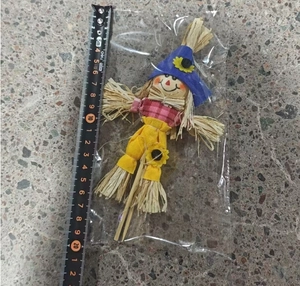Detail of 22cm wooden scarecrow stake with blue hat and sunflower decoration in packaging
