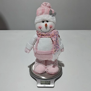 Detailed view of a pink sequined snowman figure showing 325g weight on a digital scale