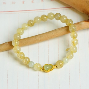 Natural rutilated quartz 7mm bead bracelet with a jade gourd pendant on a wood branch