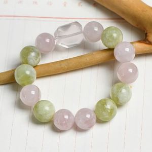 Bracelet en quartz rose et jade vert avec perle géométrique sur une branche en bois